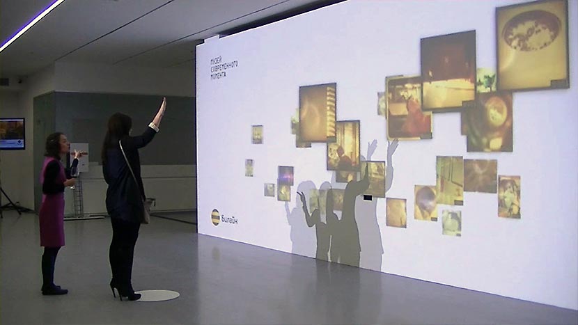 Зрители управляют жестами изображением на экране интерактивной инсталляции.